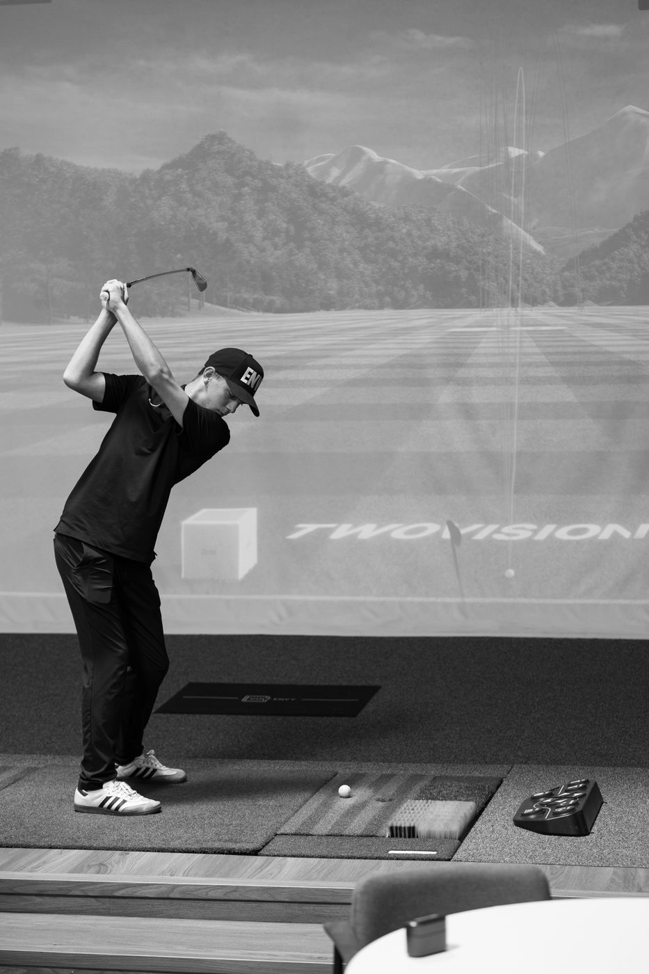 Junior golfer swinging on a Golf Envy simulator