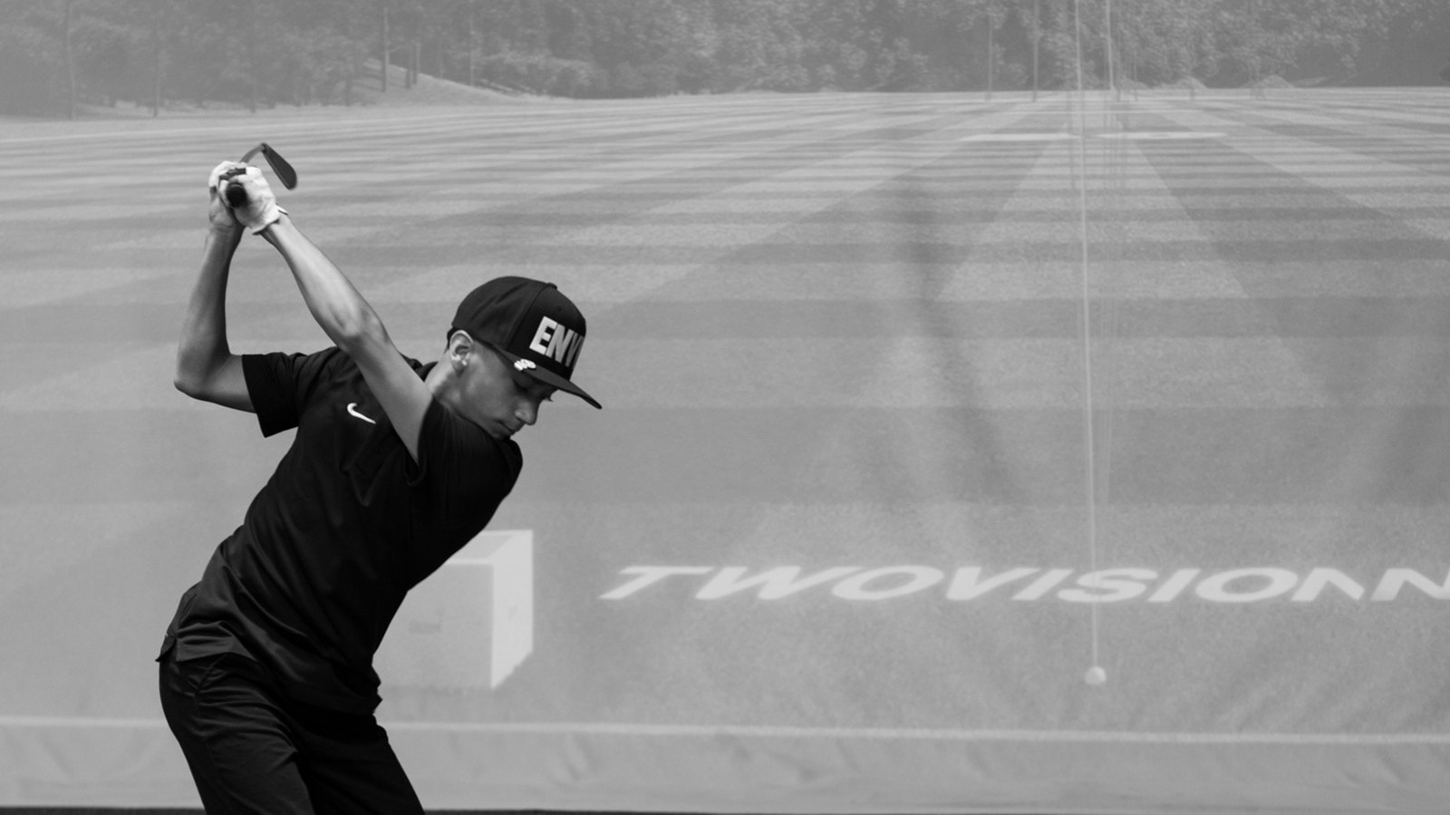 Junior golfer following through on a drive at Golf Envy